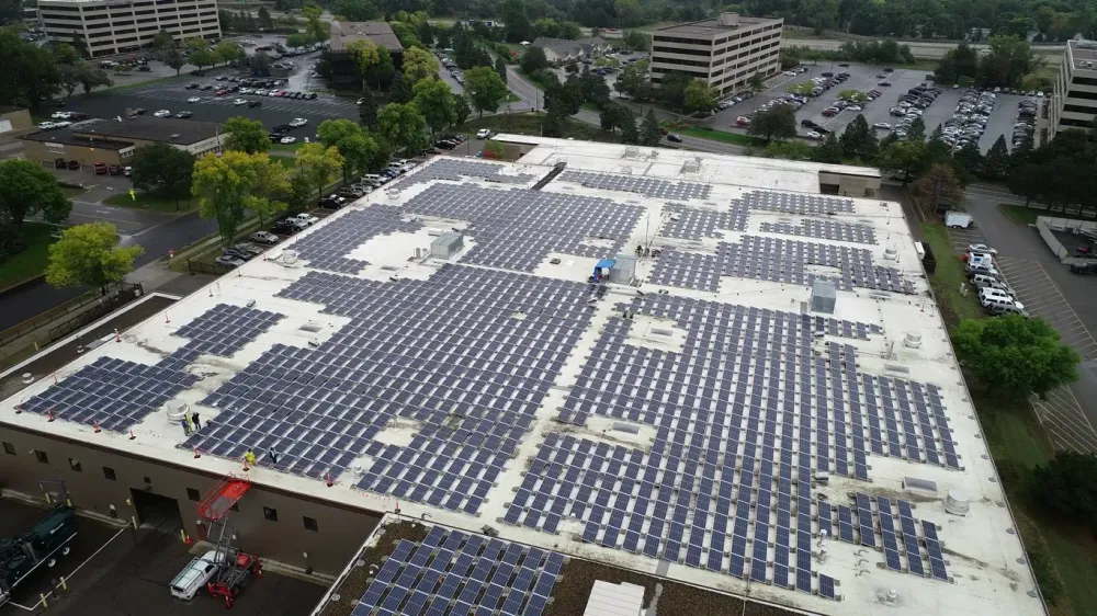 A wide, aerial view of the Edina public works building, covered in an array of solar panels
