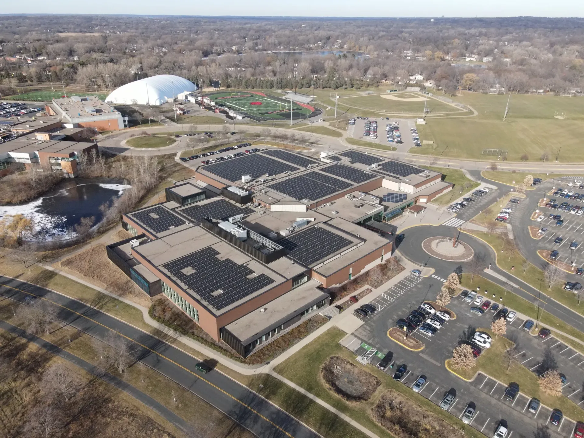 Arial photo of a municipal buildings with large flat roofs covered in solar panels.