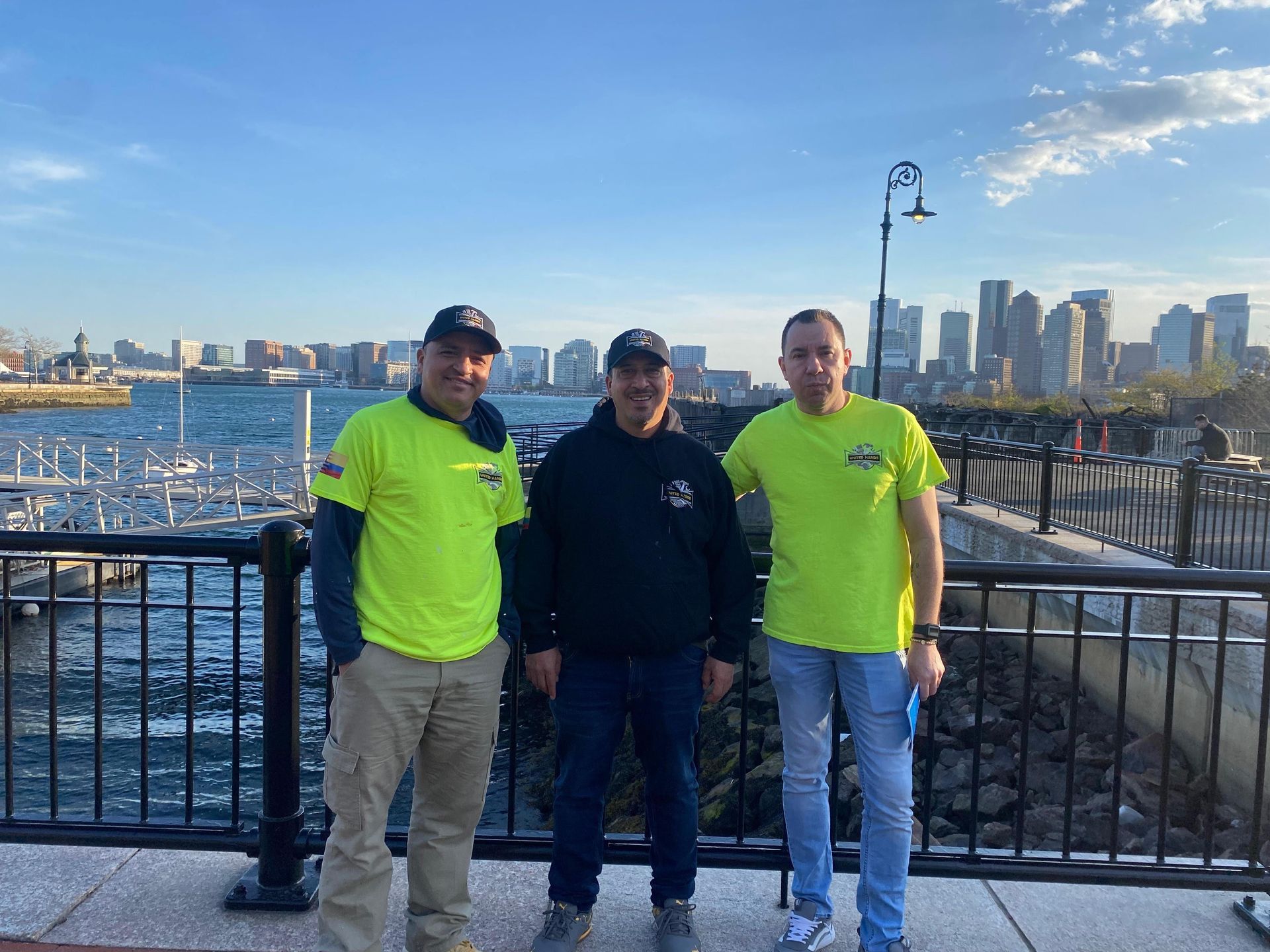 Four handymen in black uniforms standing in a renovated building