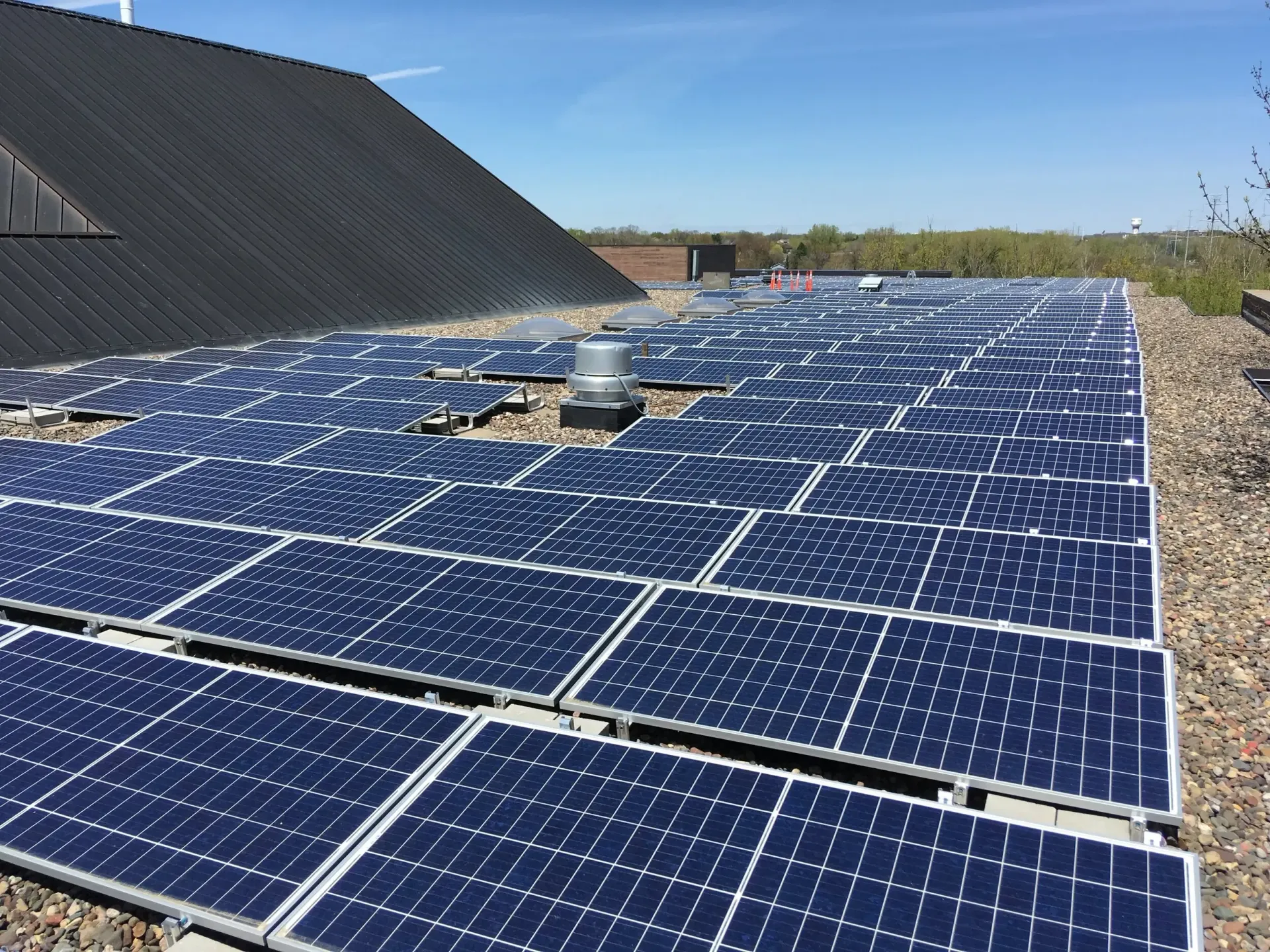 An array of dozens of solar panels on a rooftop